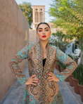 Beautiful woman poses in an ornate, patterned coat