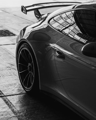 A sleek porsche in monochrome sits stationary.