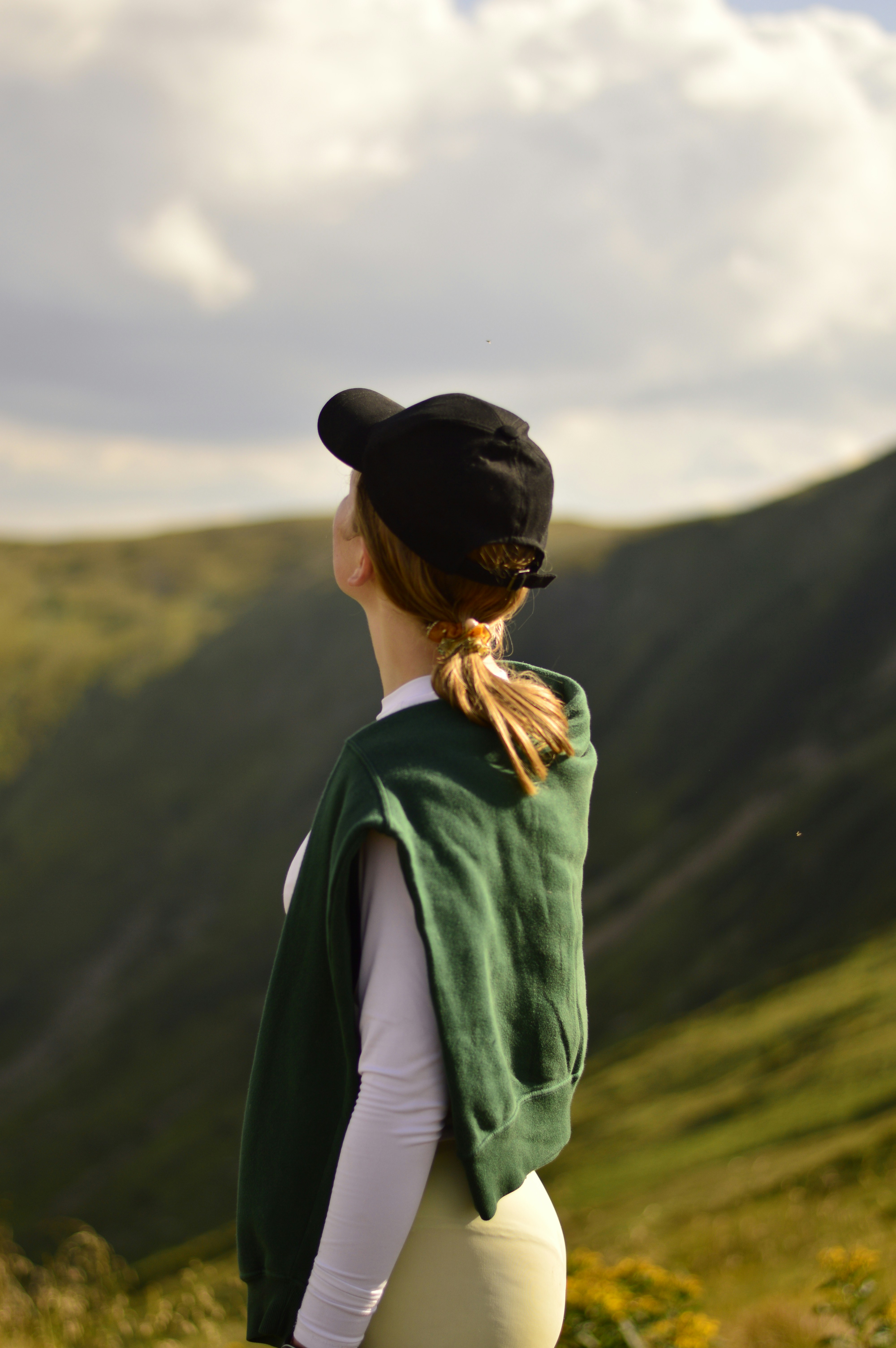 Woman looks up at mountains