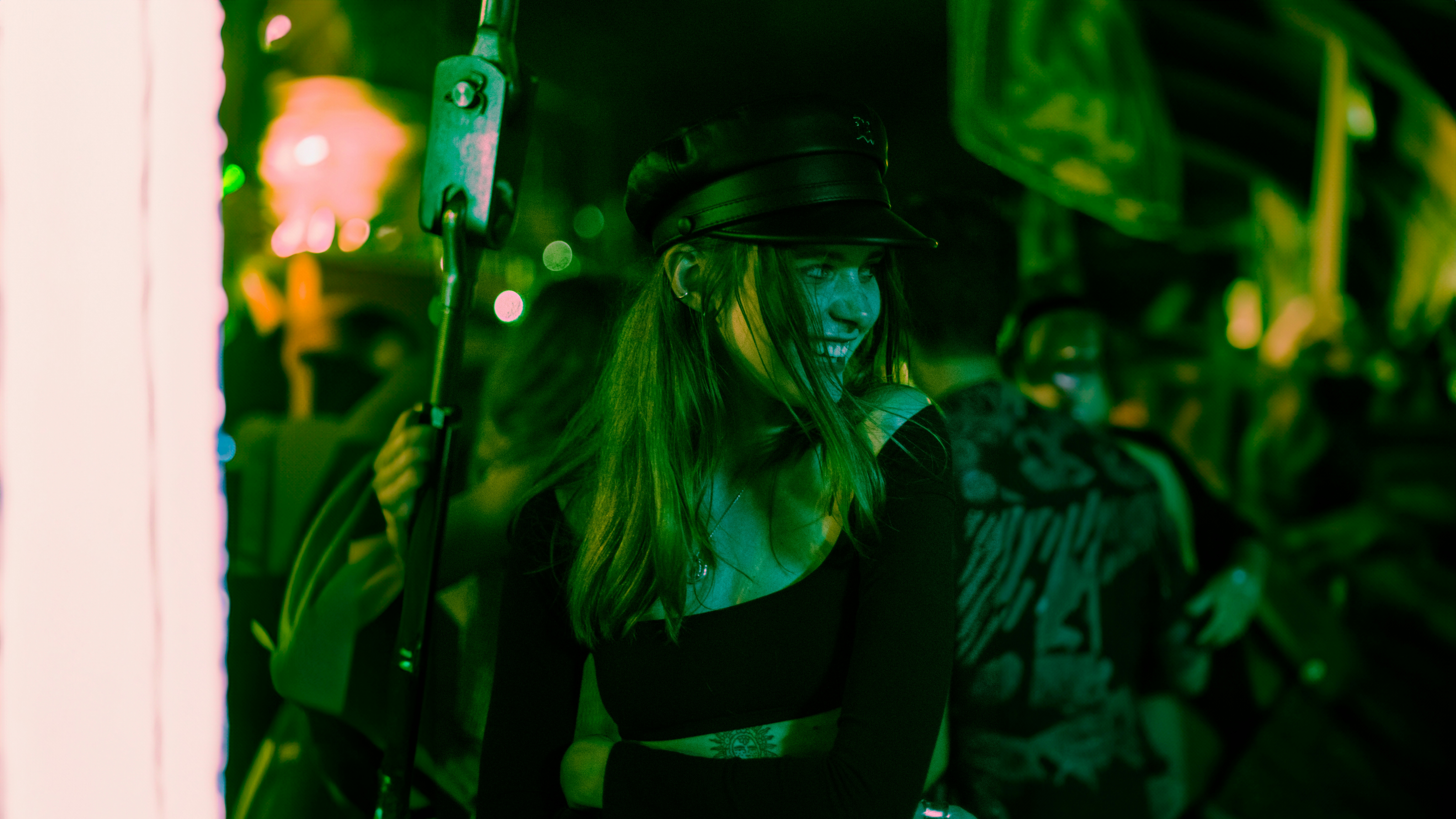 Una mujer sonríe en un evento al aire libre por la noche.