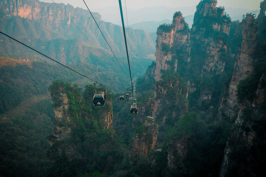 Cable cars traveling through mist-shrouded sandstone mountain spires at Tianzi Mountain