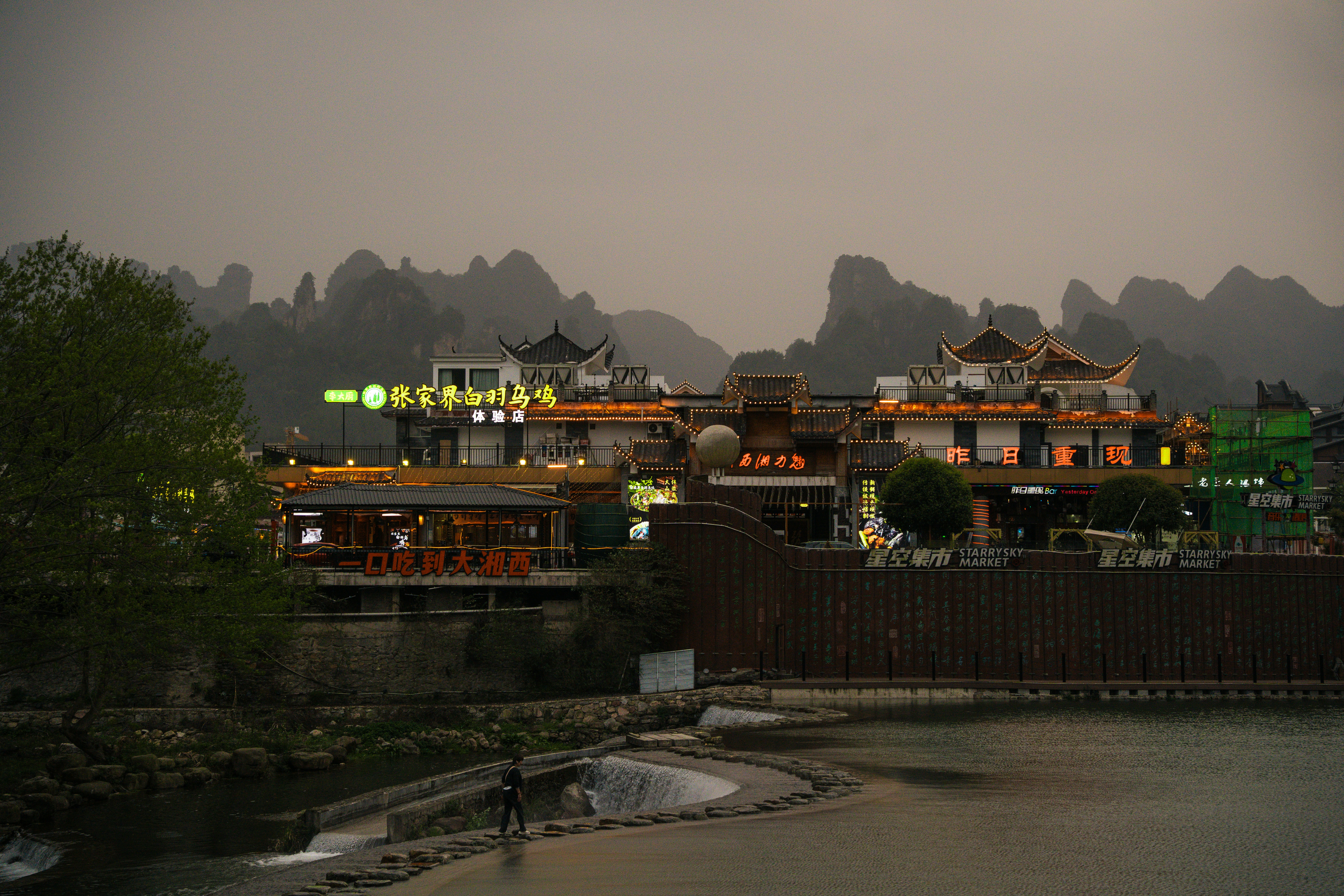 Buildings shine brightly against a backdrop of mountains