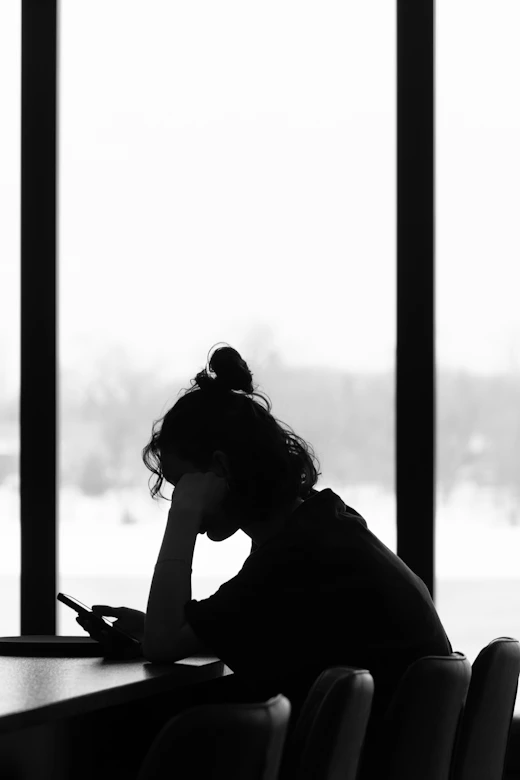 A silhouette of a person on their phone