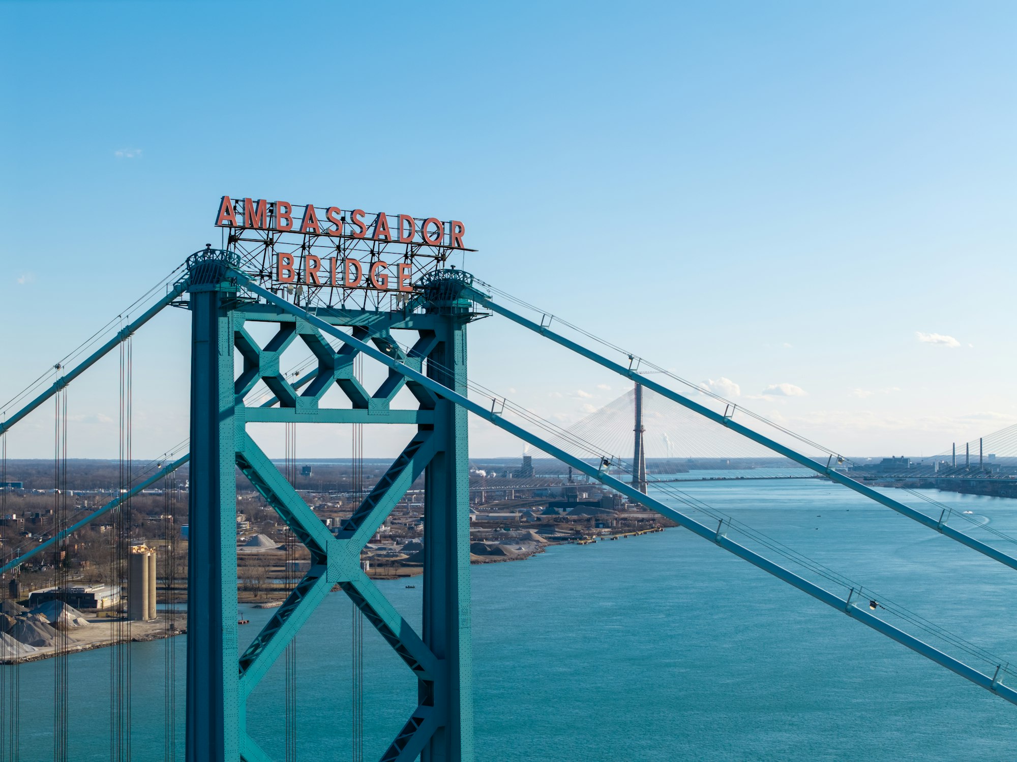 The ambassador bridge stands tall over the water.