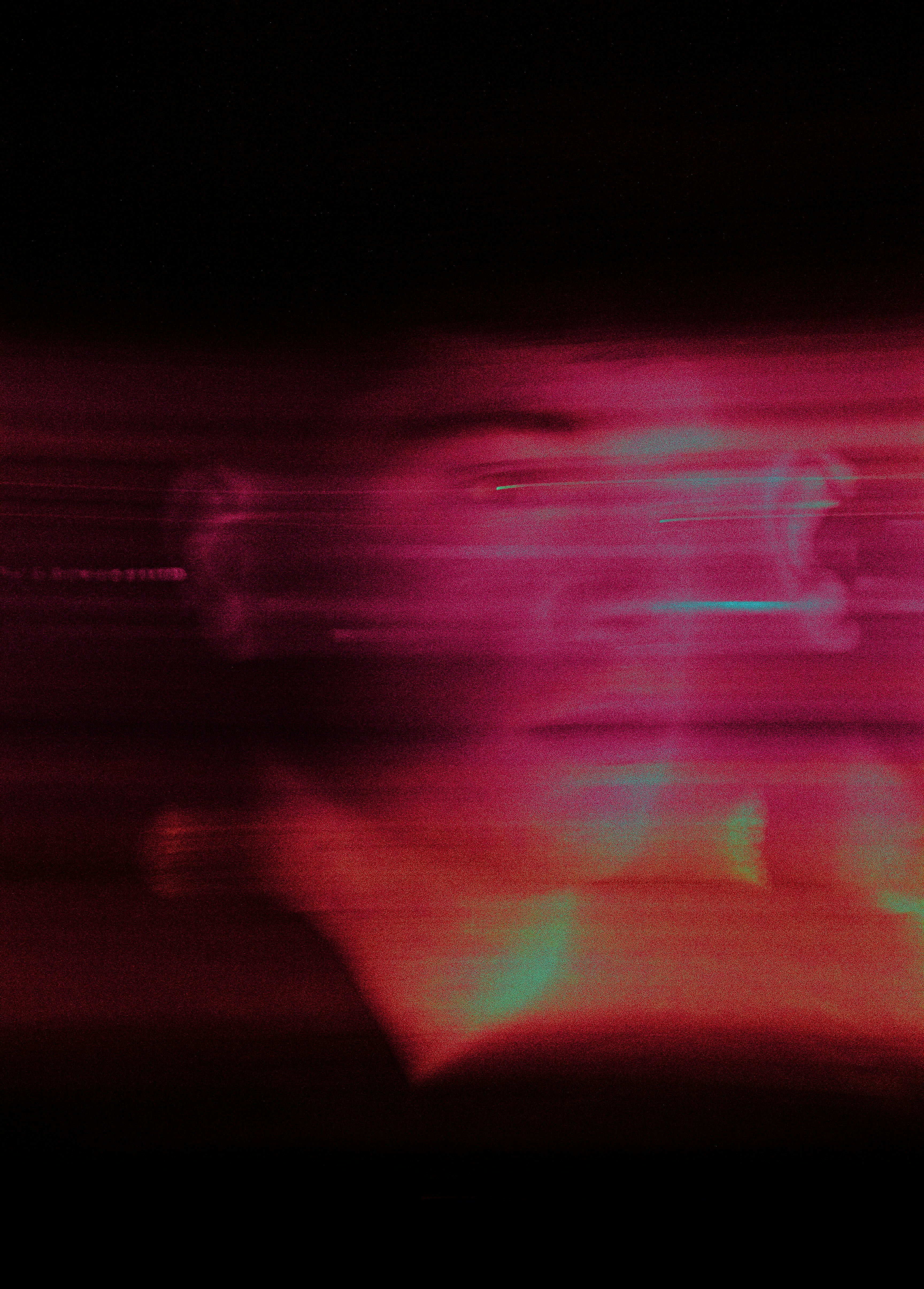 Blurred red and purple light streaks against black.