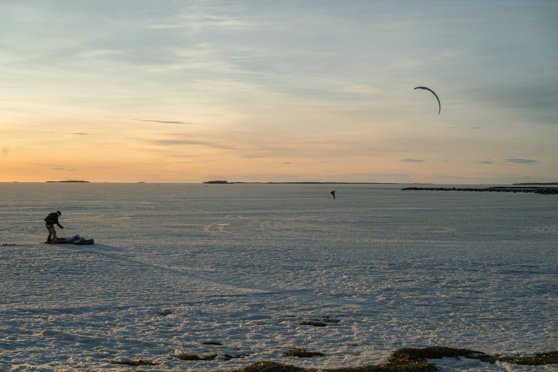 A person ice kiting on a snowy, frozen landscape.
