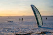 Kite-skiing on a snow-covered landscape at sunset