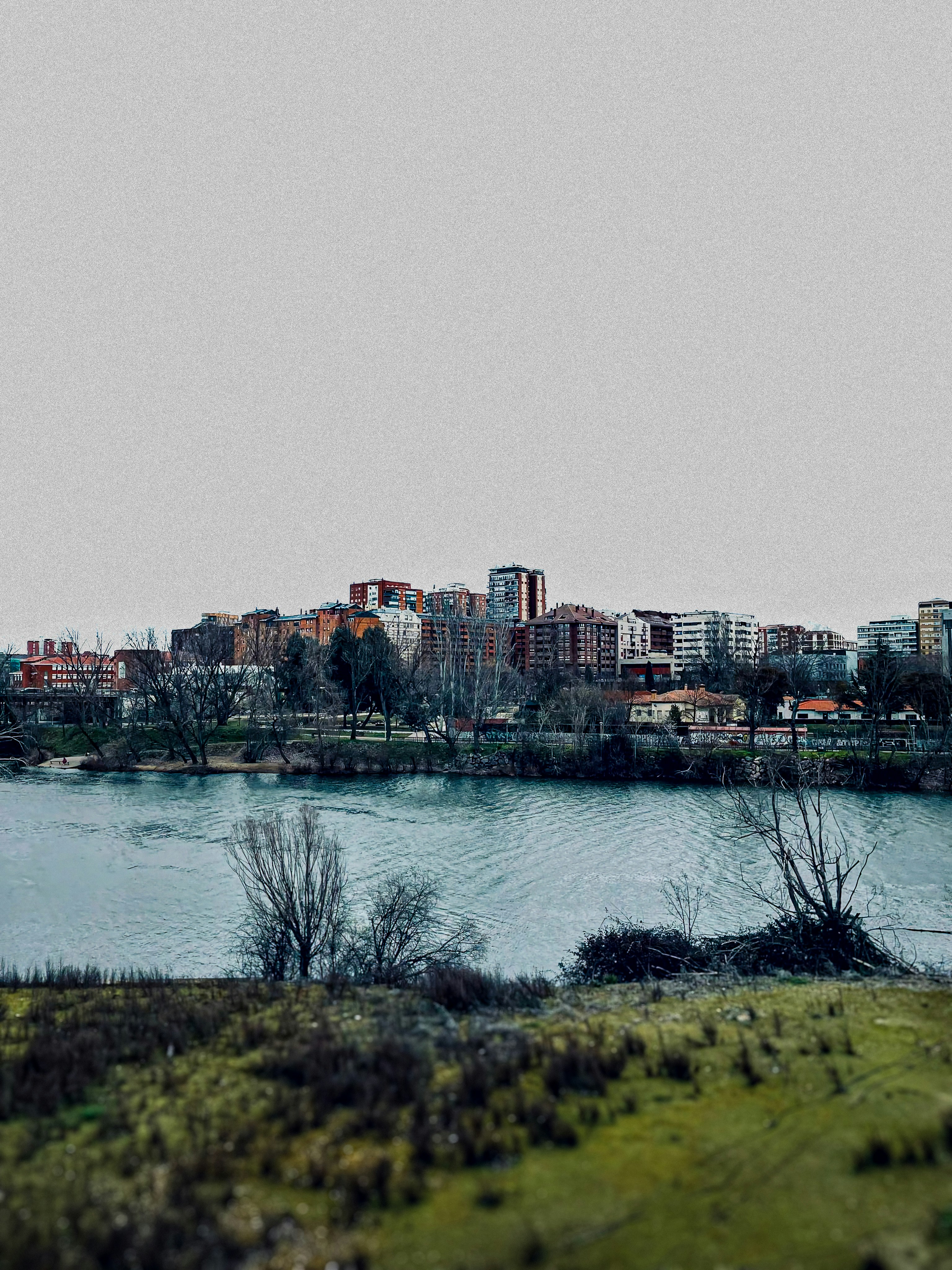 Skyline da cidade que negligencia um rio em um dia nublado