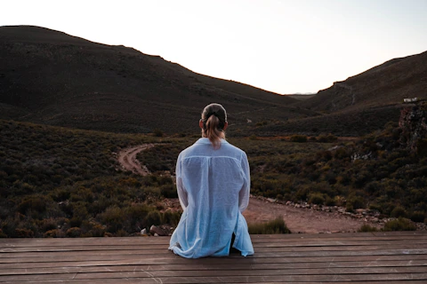 Woman contemplates a vast landscape from a deck