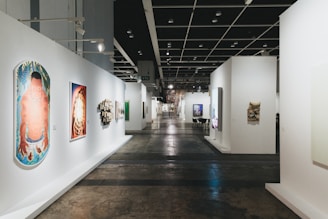 A long gallery hallway with various art displays.