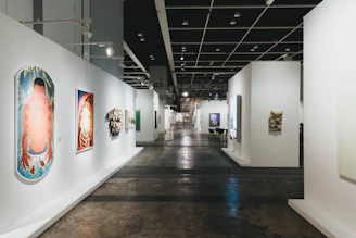 A long gallery hallway with various art displays.