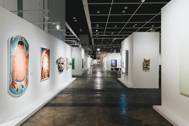 A long gallery hallway with various art displays.