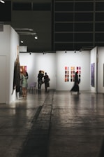 People browse art in a brightly lit gallery.