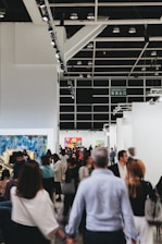 People mill about an art exhibition hall.