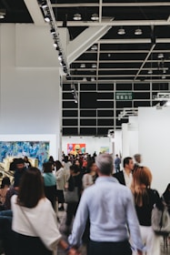 People mill about an art exhibition hall.