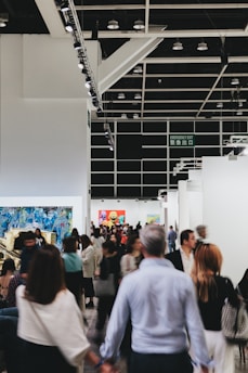 People mill about an art exhibition hall.