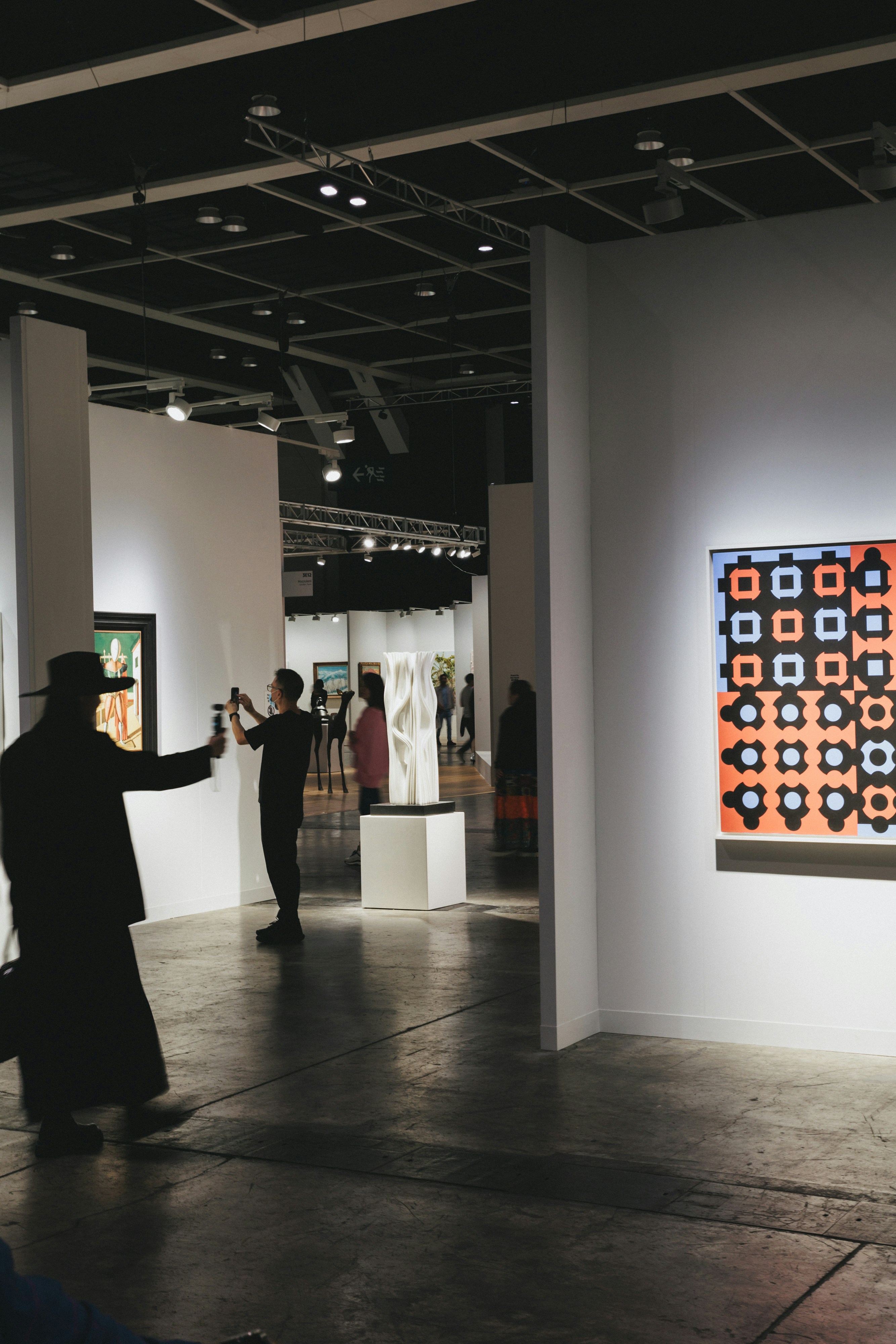 People view art at an exhibition.