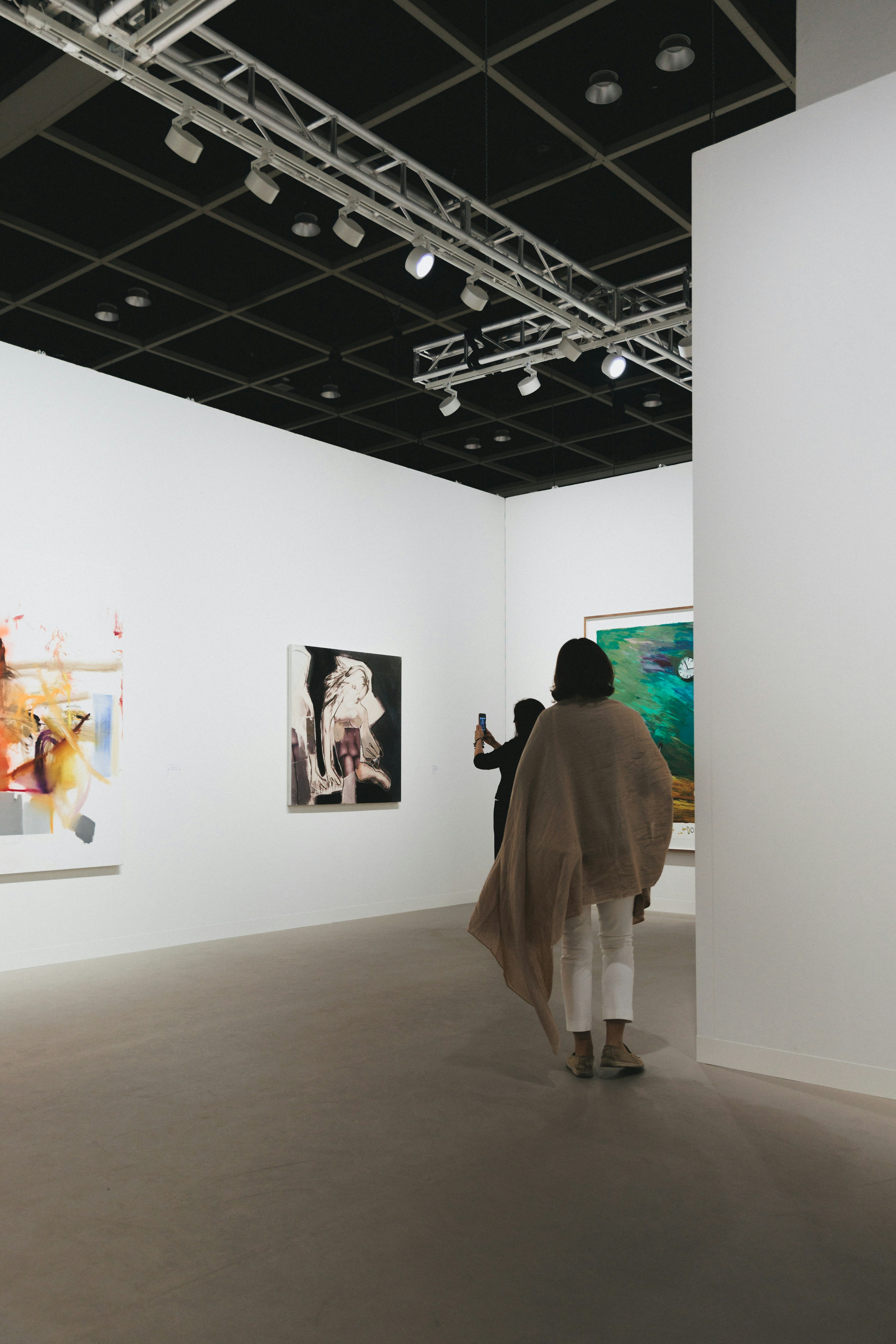 People viewing art in a brightly lit gallery.