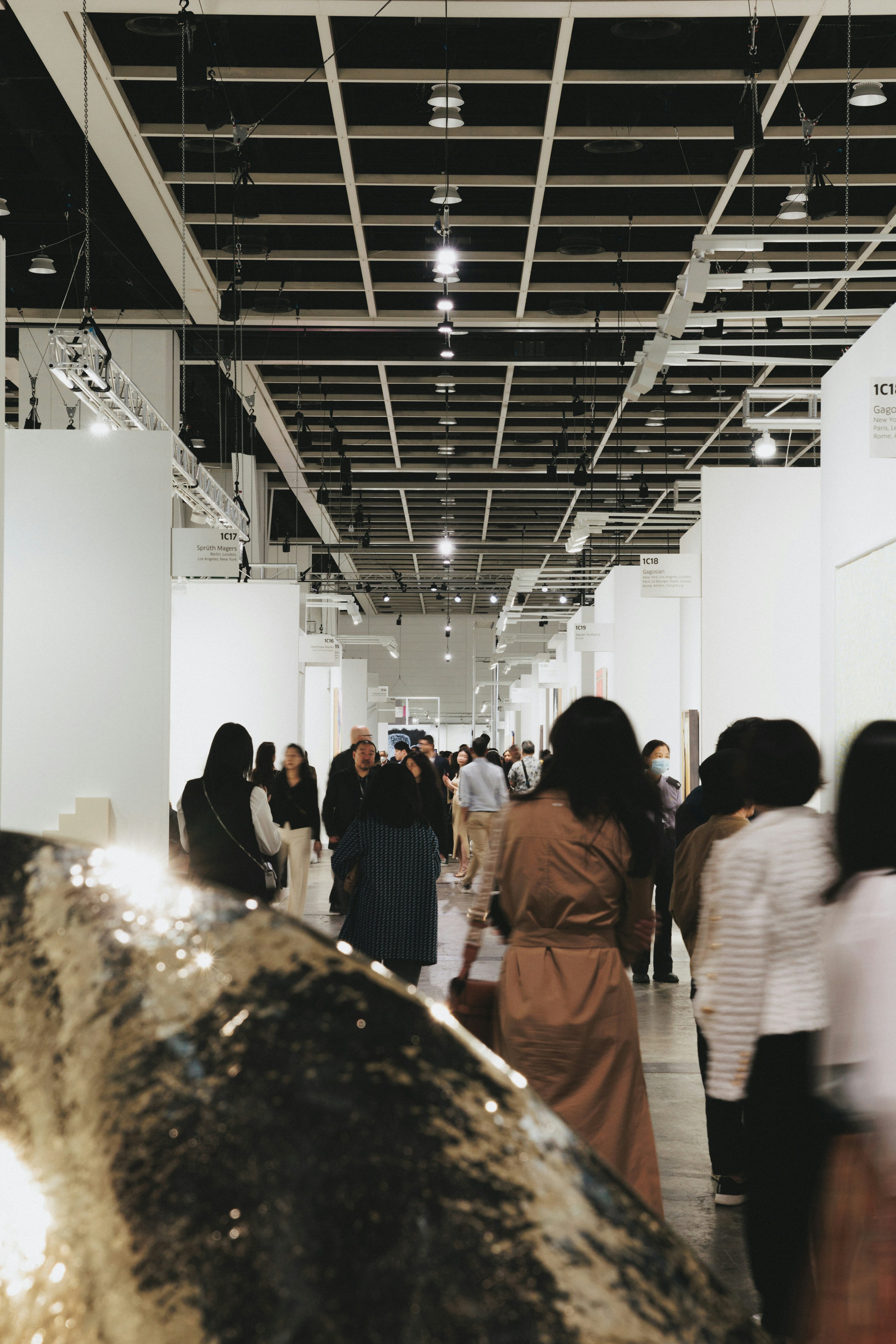 People walk down a gallery hallway.