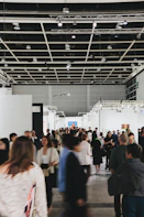 People browse art in a busy, modern gallery