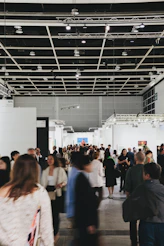 People browse art in a busy, modern gallery