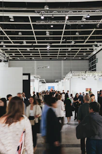 People browse art in a busy, modern gallery