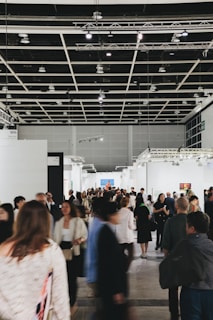 People browse art in a busy, modern gallery.