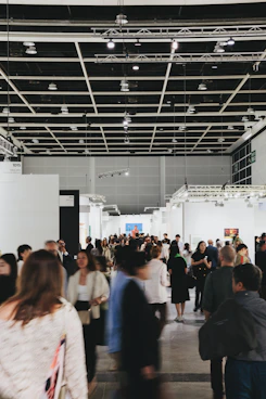 People browse art in a busy, modern gallery