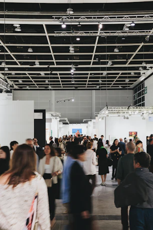 People browse art in a busy, modern gallery