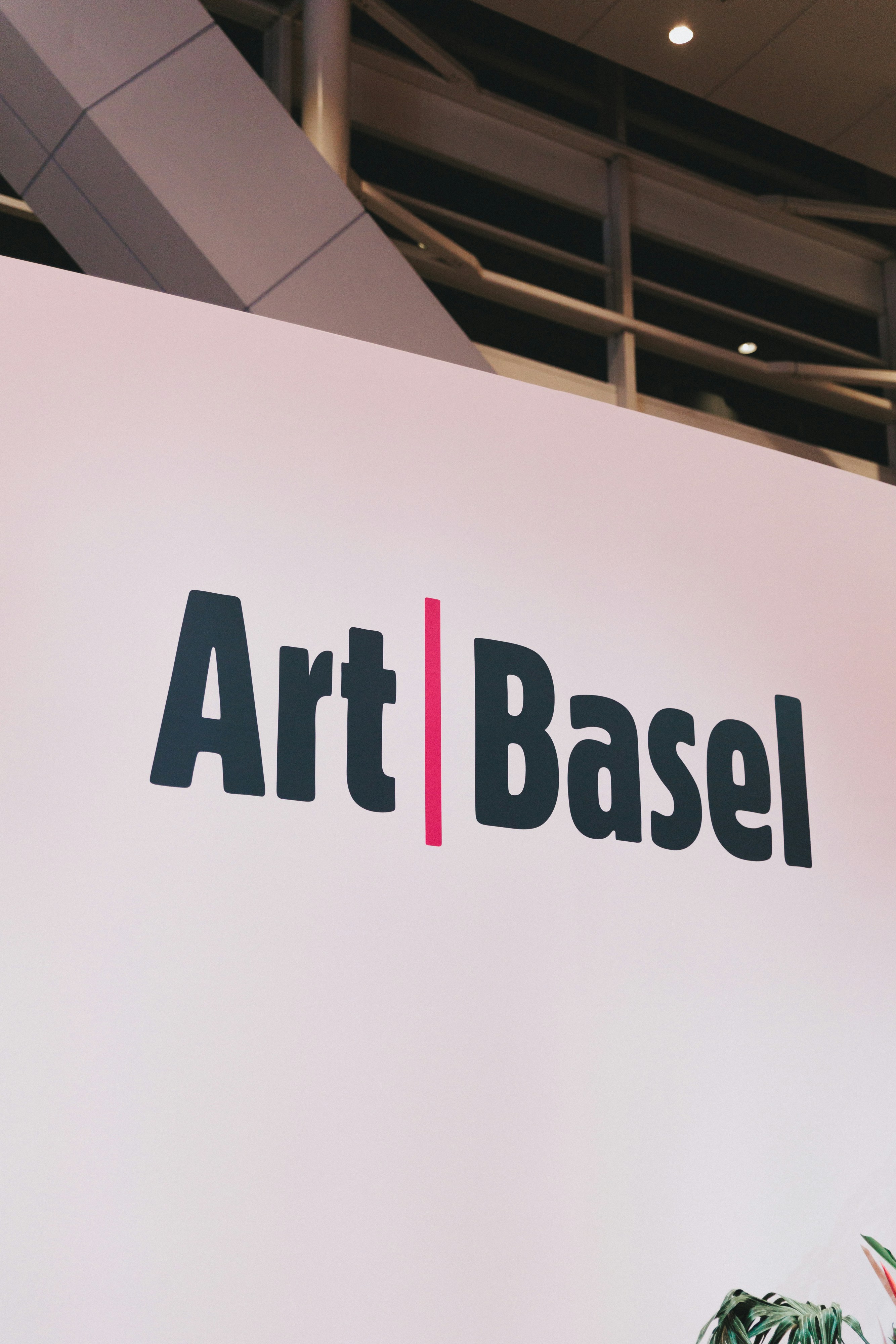Art basel logo on a white wall.
