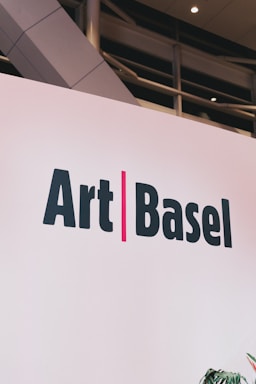 Art basel logo on a white wall.
