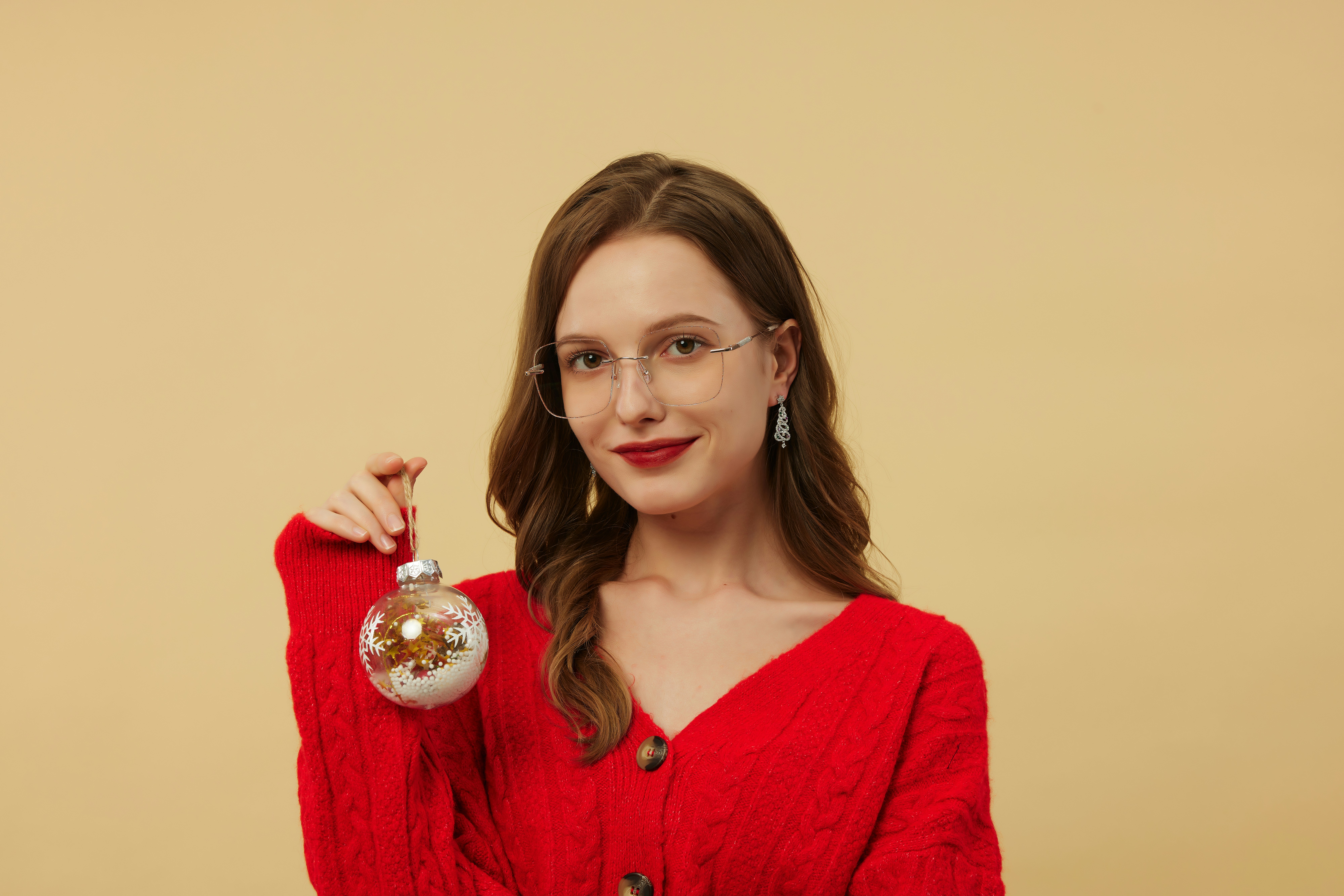 Frau hält einen Weihnachtsschmuck.