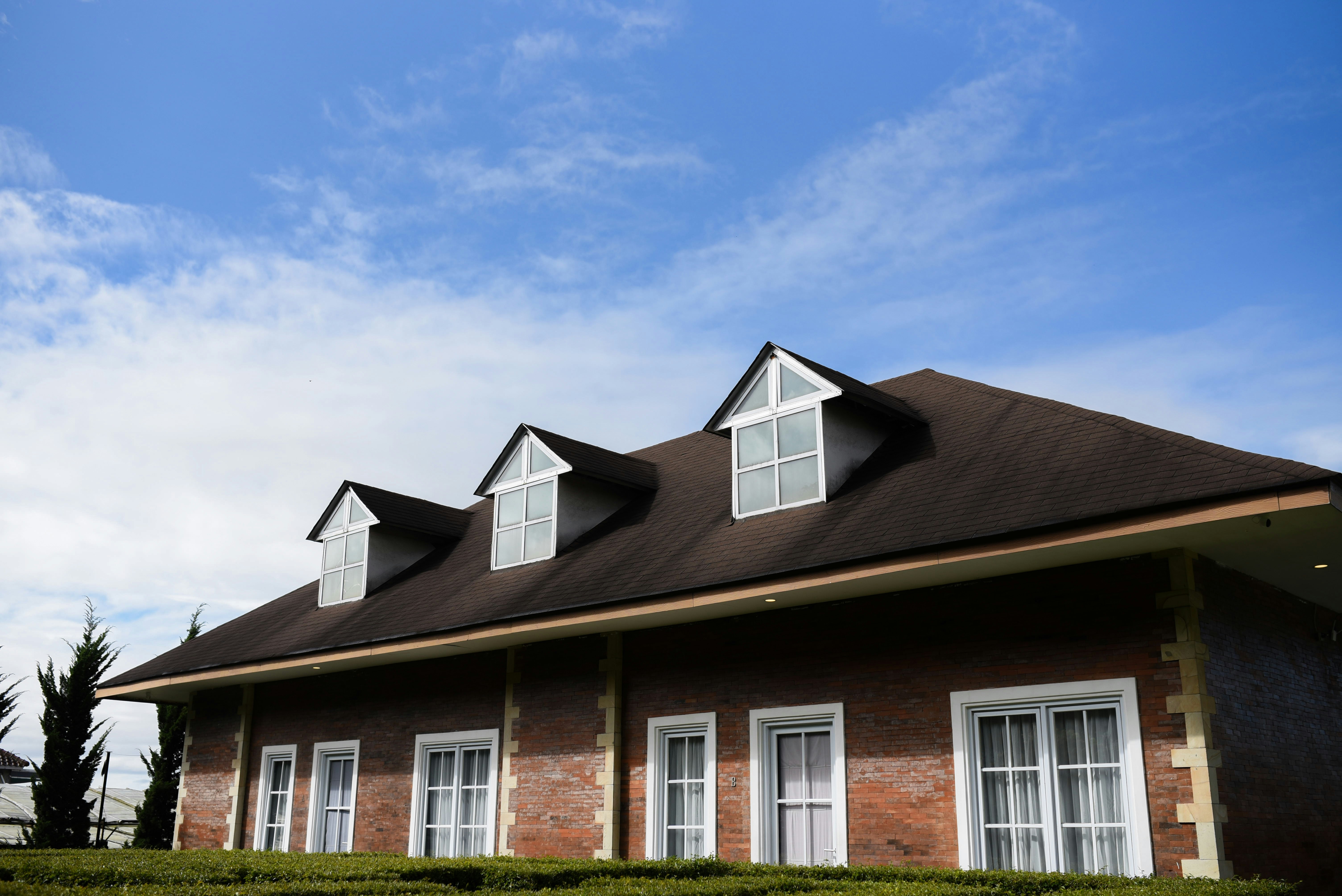 A beautiful brick house underneath a blue sky.