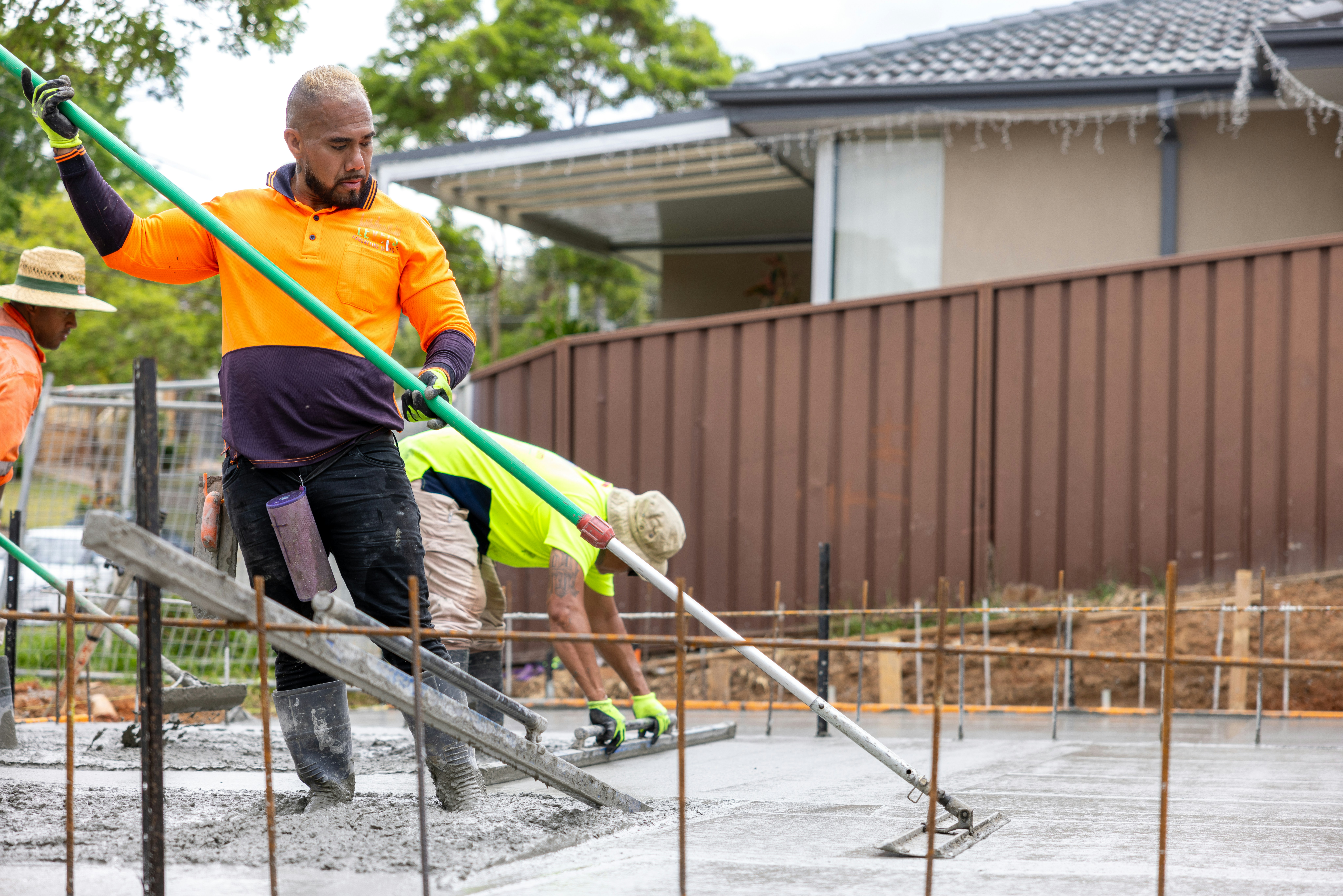 Construction workers are smoothing concrete on a new slab.