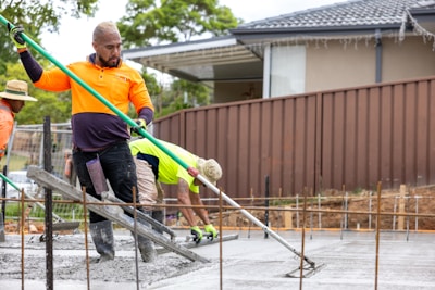 Construction workers are smoothing concrete on a new slab.