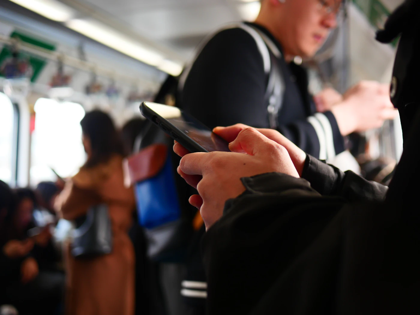 Pasajero usando el móvil en un vagón de metro lleno