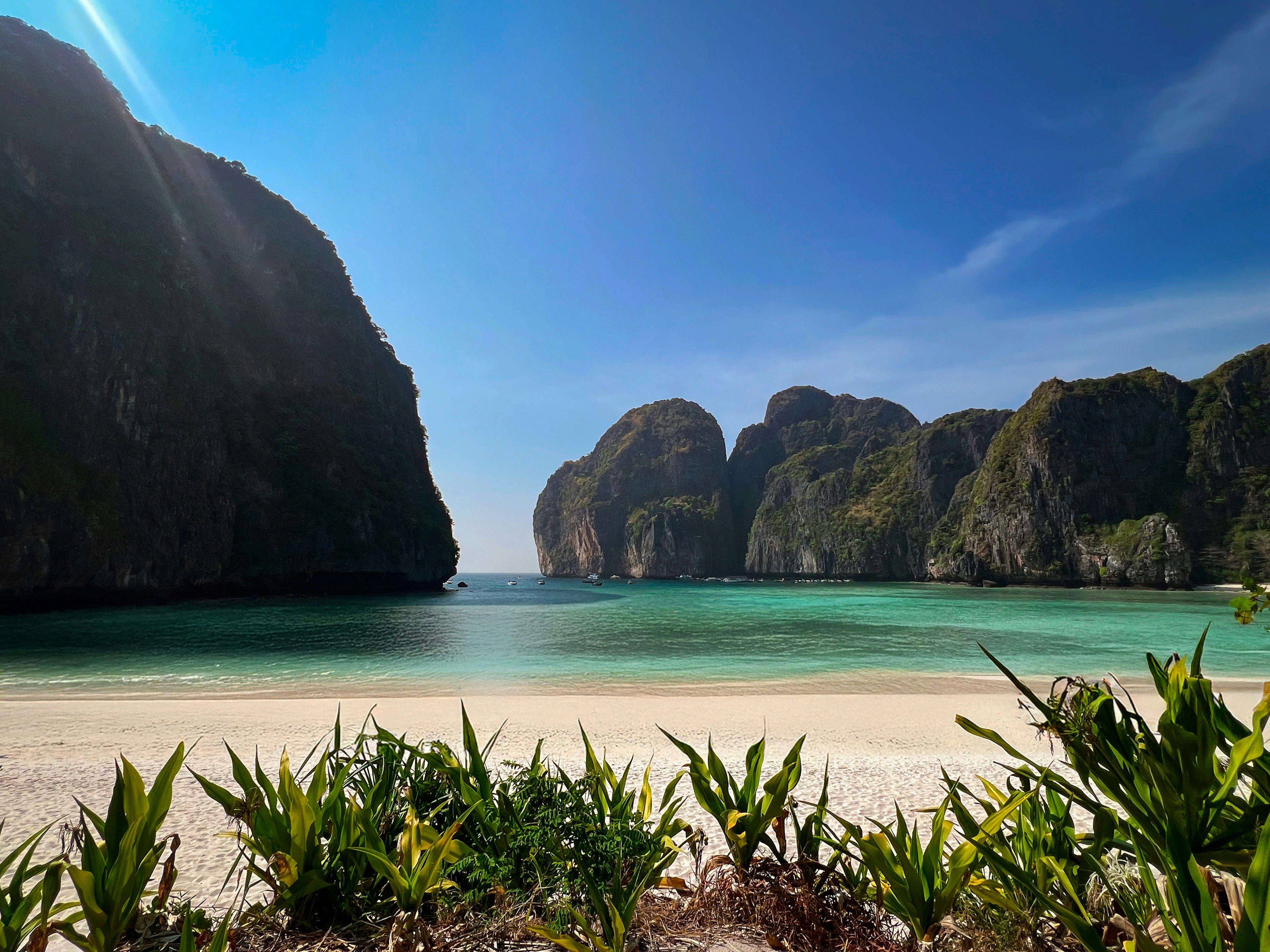 Beautiful beach with clear water and rocky cliffs.