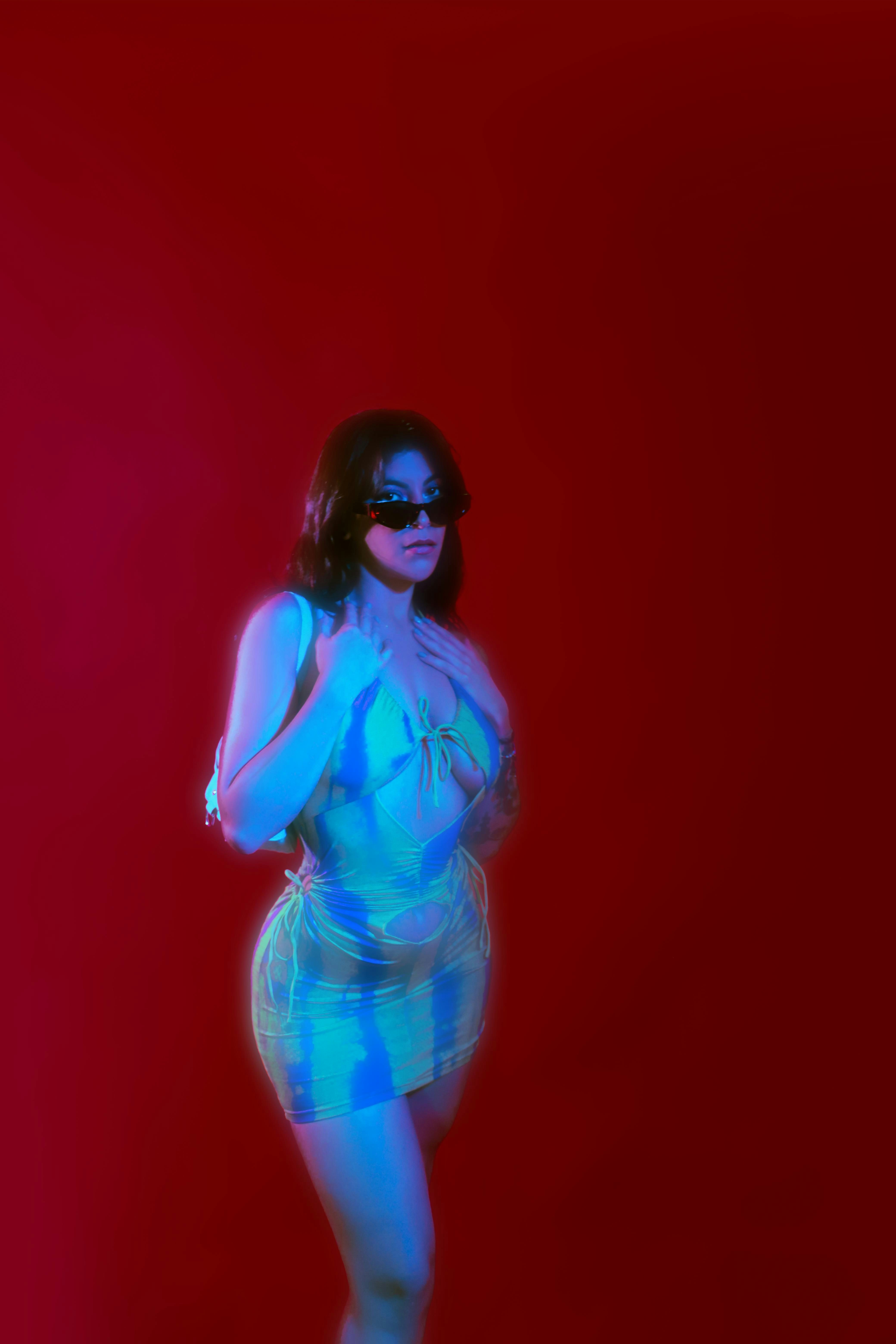 A woman poses in vibrant colors and sunglasses