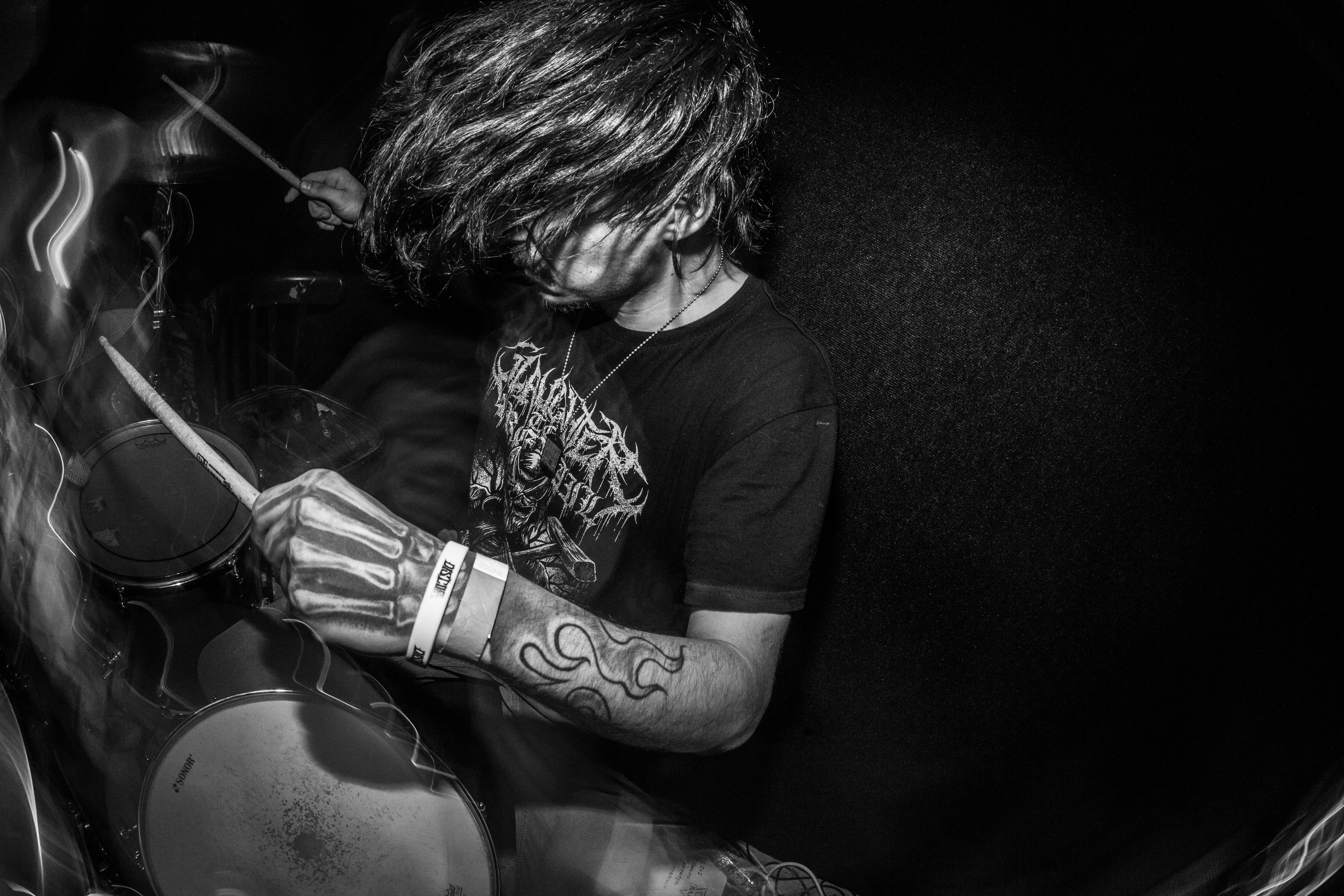 A drummer plays their instrument on stage.