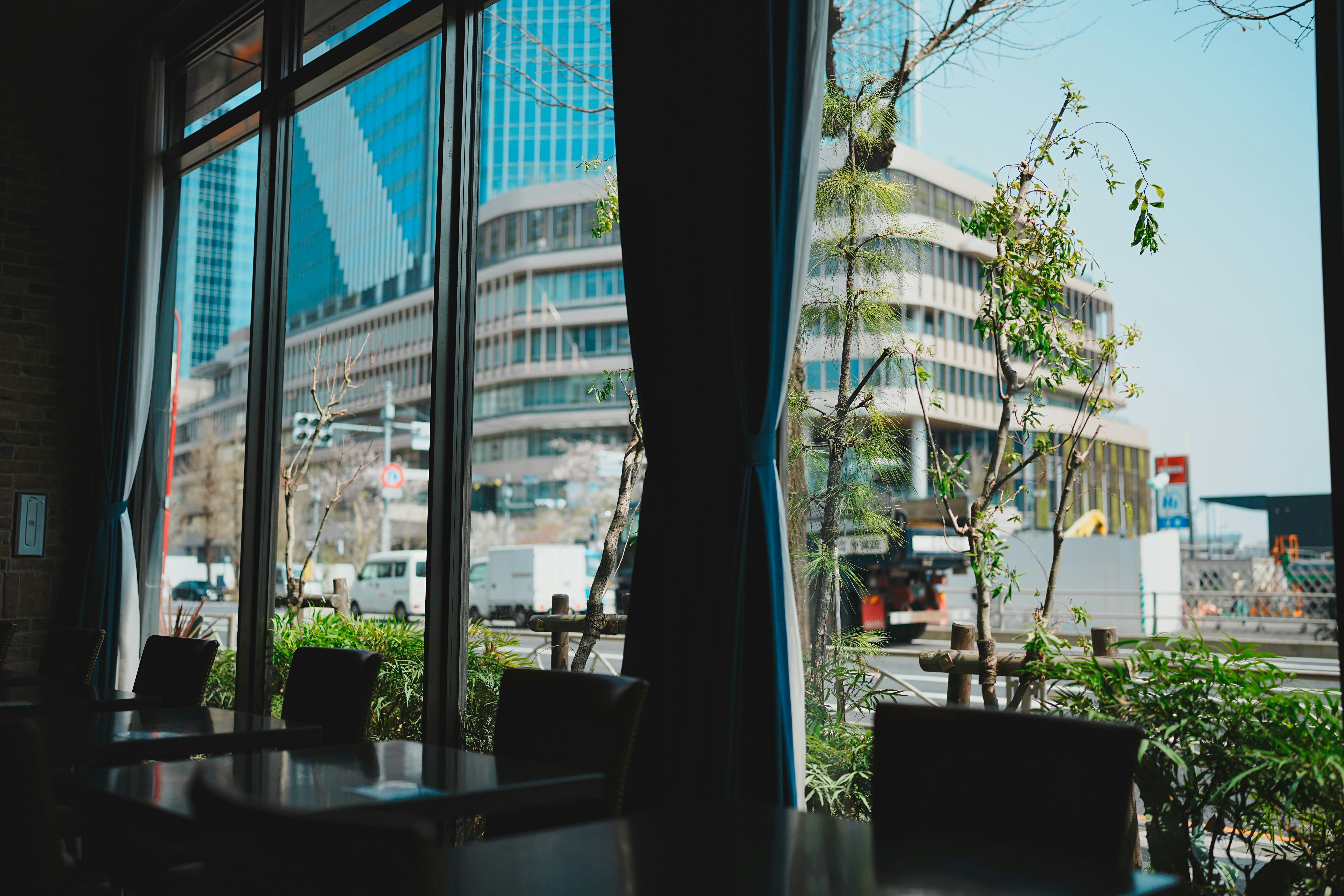 Inside view of a restaurant with city buildings outside.