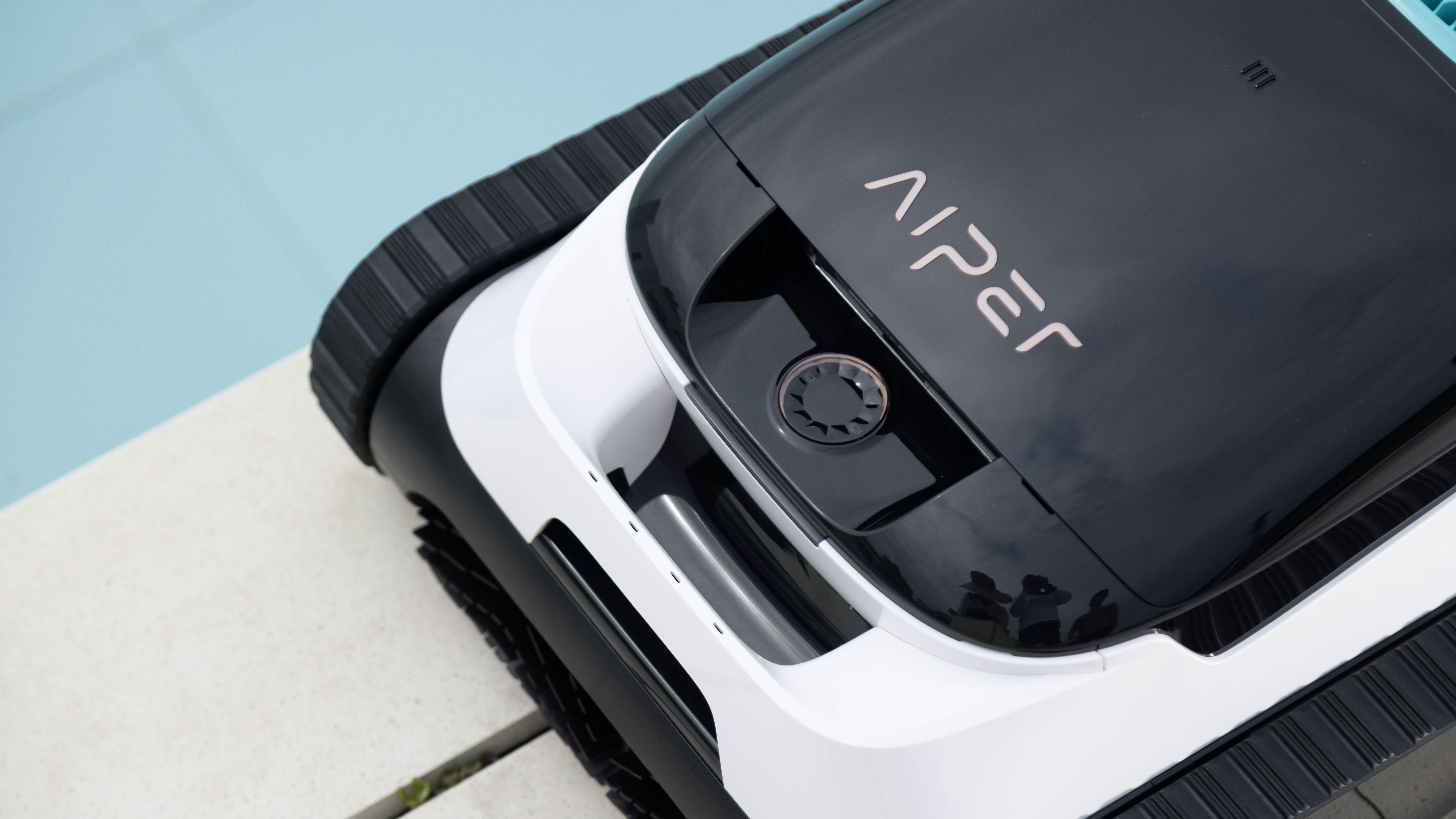 A pool cleaning robot rests beside the pool.