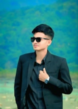 Stylish young man poses in a black suit.