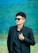 Stylish young man poses in a black suit.