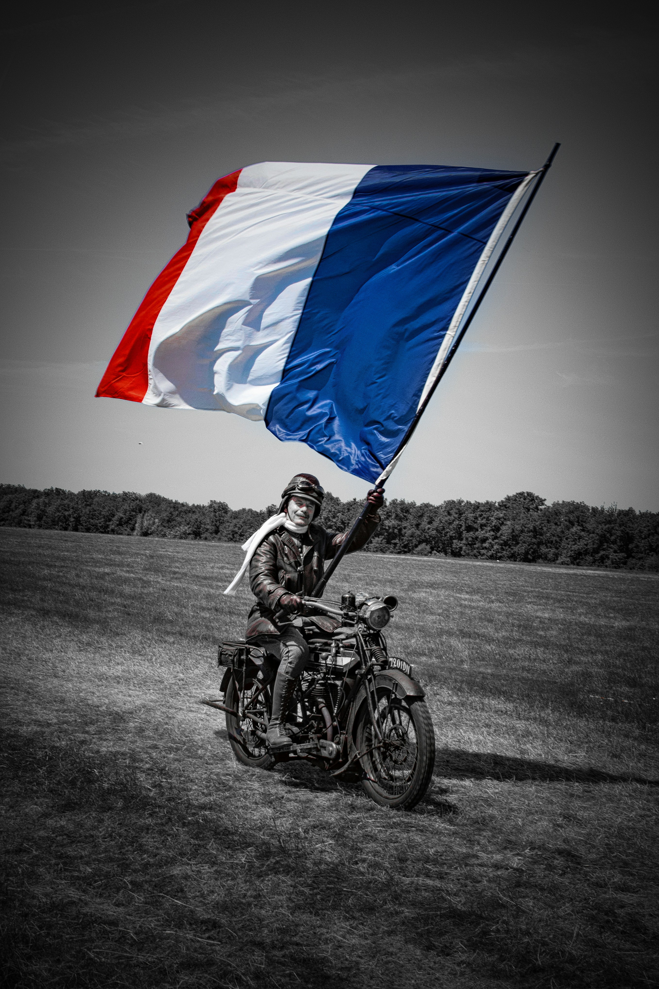 Ein Motorradfahrer schwenkt stolz die französische Flagge.