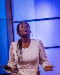 Woman looks up with arms outstretched.