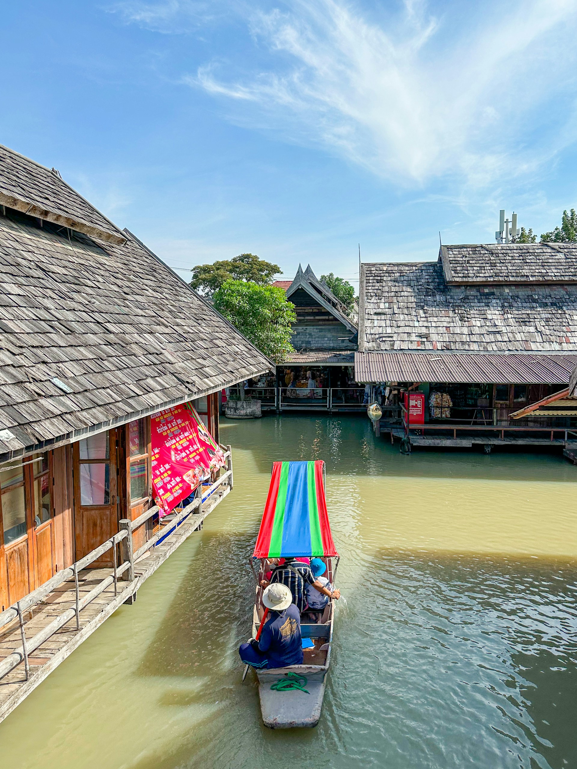 A boat navigates a canal through a market.