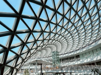 An intricate, glass dome roof against a blue sky.