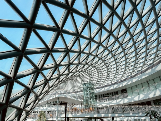 An intricate, glass dome roof against a blue sky.