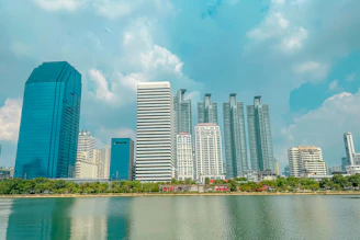 Skyscrapers line a beautiful waterfront under a blue sky.