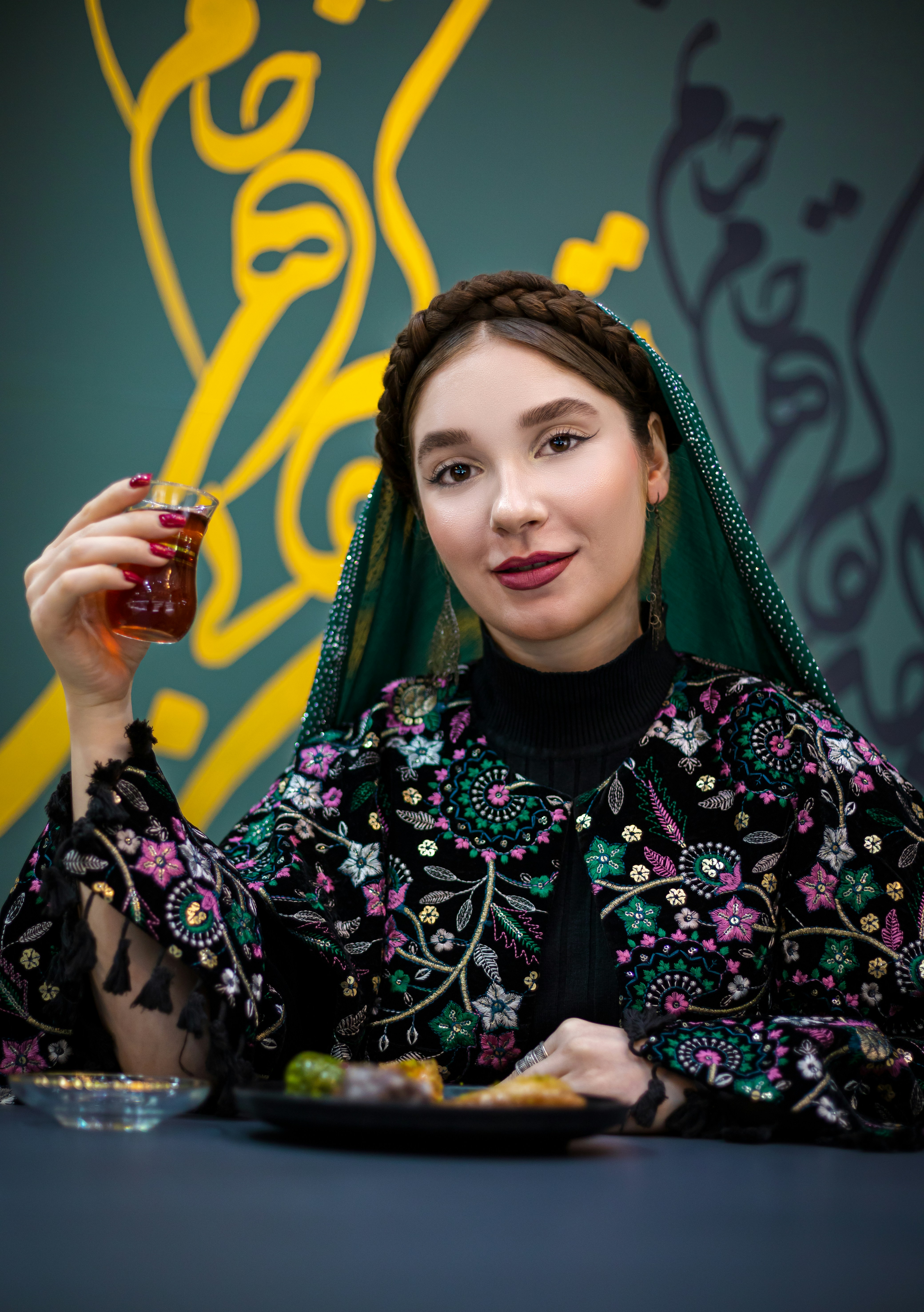 Wanita berpakaian tradisional memegang teh.